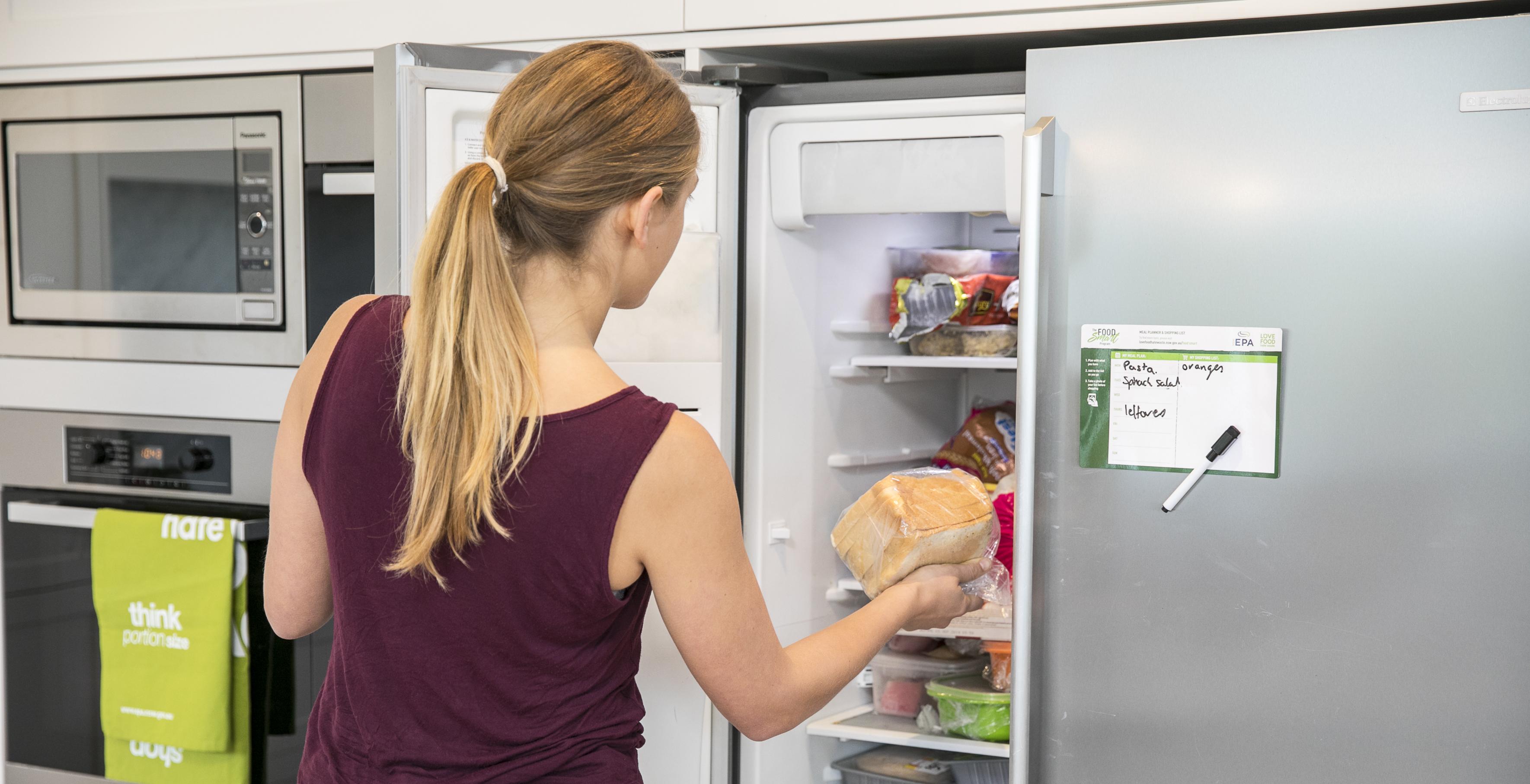 Image of woman placing bread into the freezer