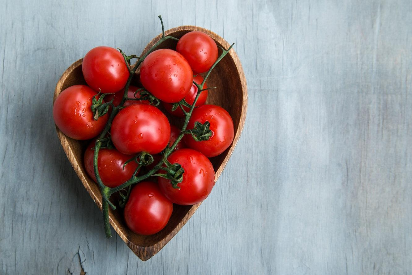 Cherry tomatoes in heart shape wooden bowl