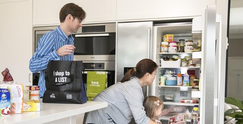 Family of three unpacking shopping