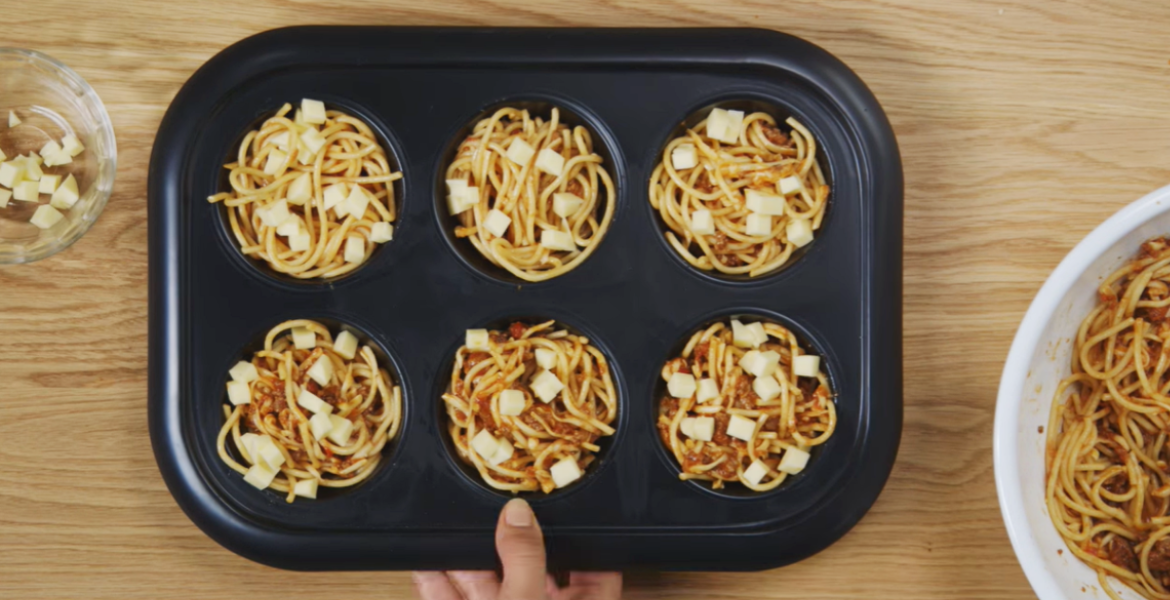 Leftover pasta stuffed into baking trays ready for the oven