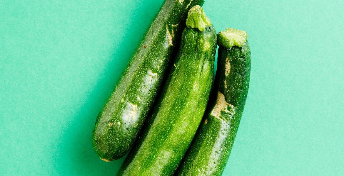 Three zucchinis on a green background