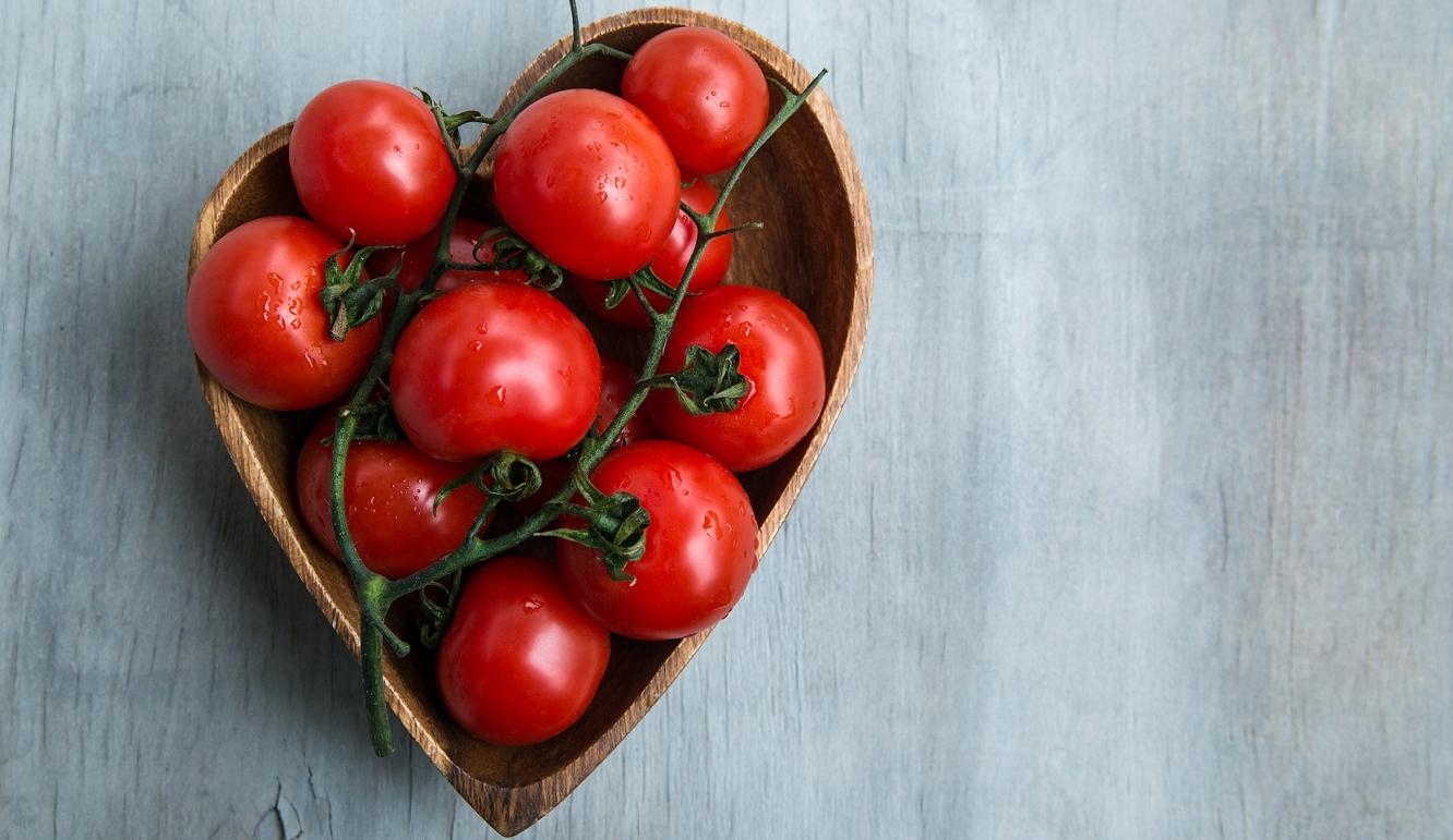 Cherry tomatoes in heart shape wooden bowl