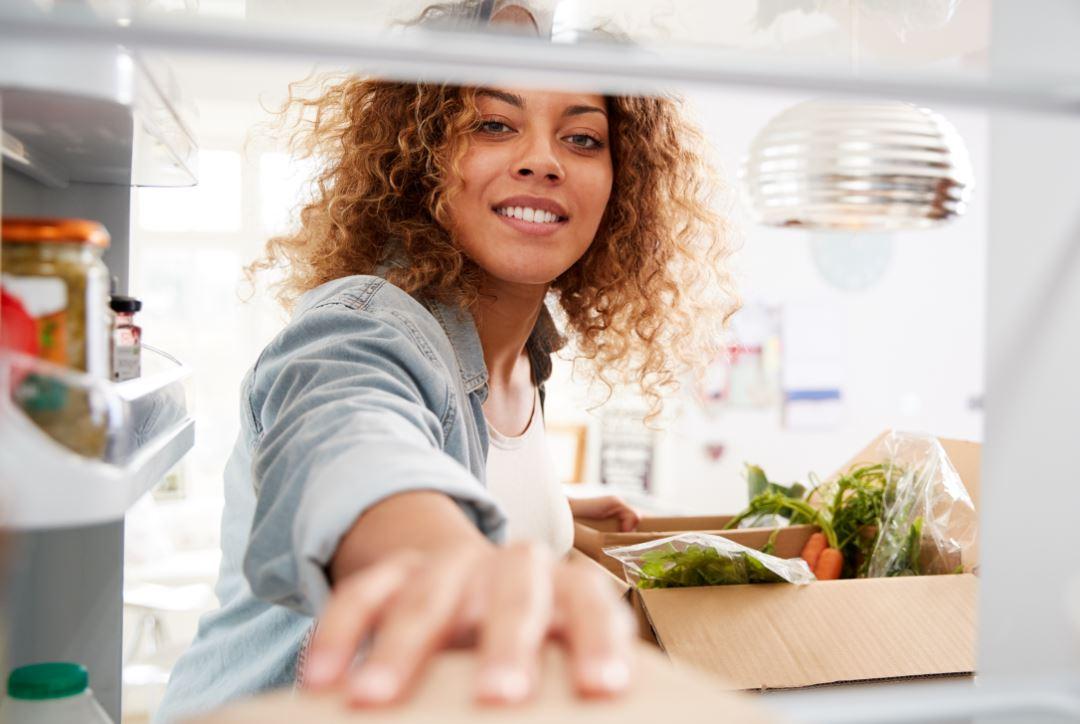 Woman taking food from fridge