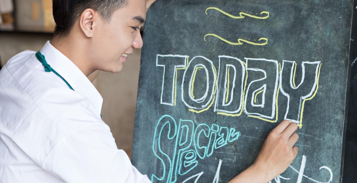 Staff writing specials on menu board