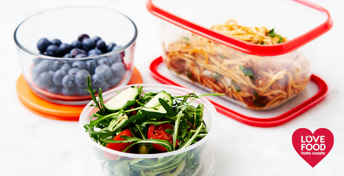 three reusable food containers with berries, salad and pasta